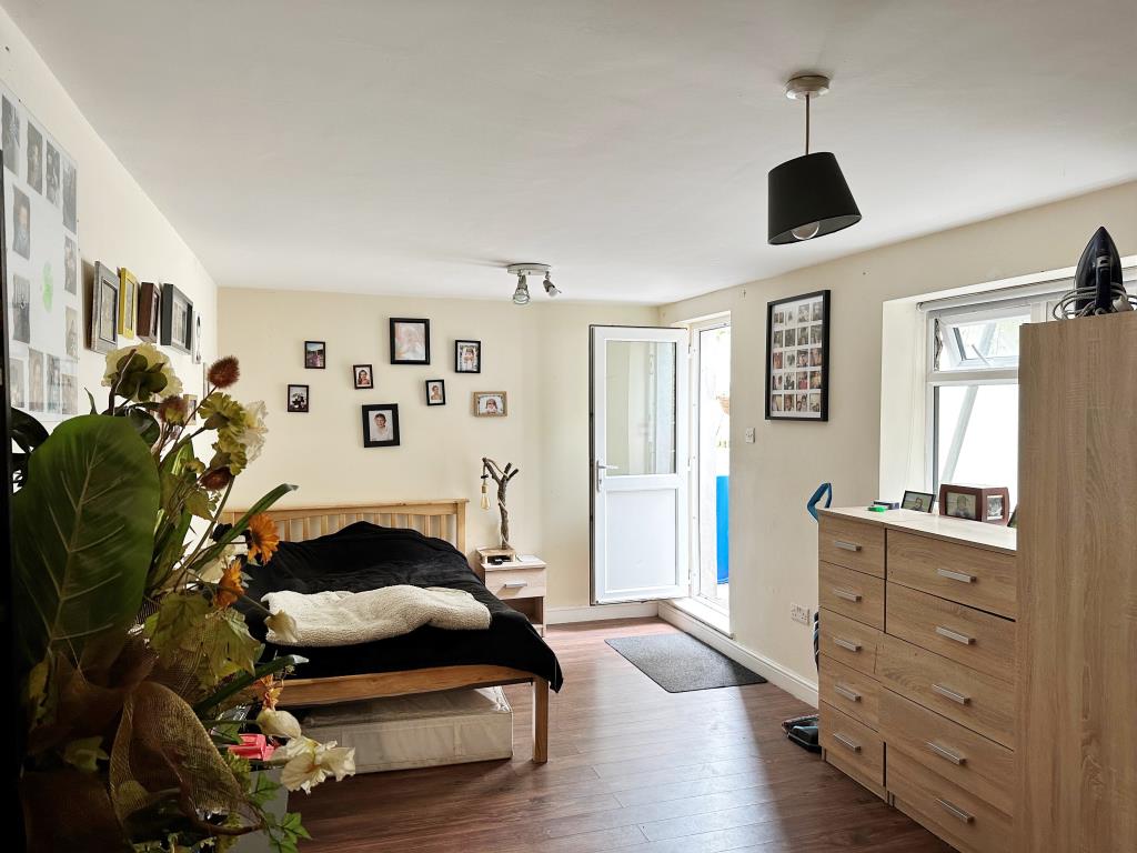 Lot: 26 - FREEHOLD BLOCK OF EIGHT FLATS FOR INVESTMENT - Flat 2 - Double bedroom with access to outside patio and garden